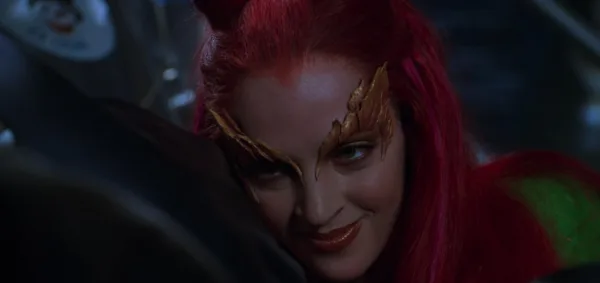 Η DC ηρωίδα Poison Ivy με κόκκινα μαλλιά και πράσινη ενδυμασία, ετοιμάζεται για δράση.